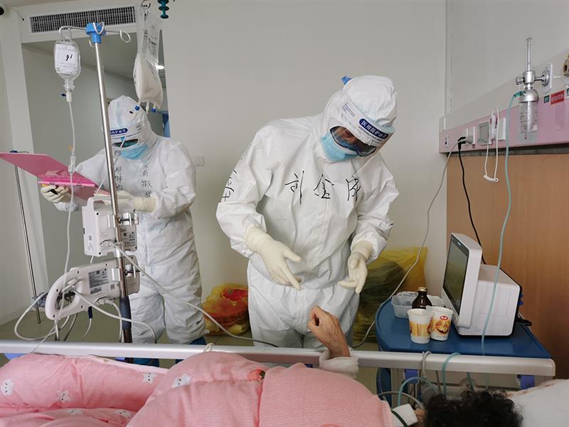空军军医大学西京医院心血管外科主任刘金成（右）在湖北省妇幼保健院光谷院区感染二科病房查看重症新冠肺炎患者生命体征（3月28日摄）。 新华社发（杜丽娜 摄）