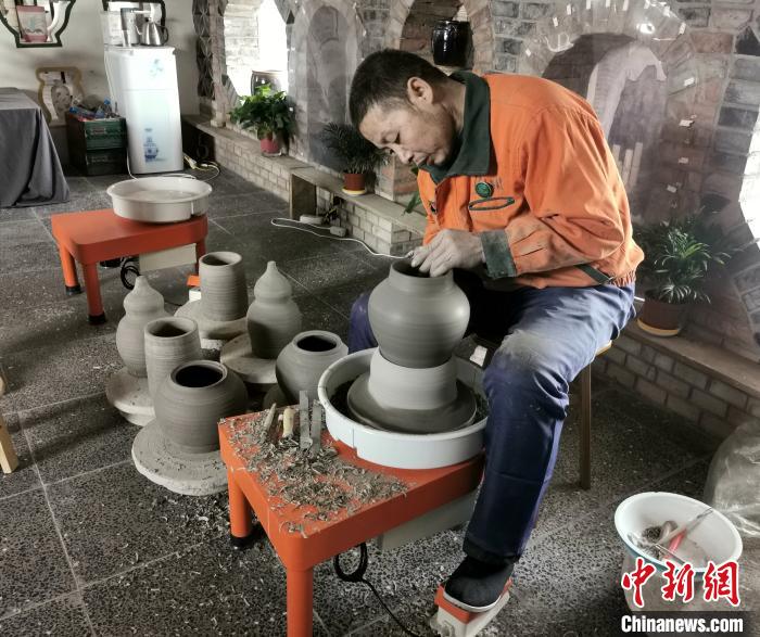 梁小板在陶瓷体验馆内忙碌着。　杨杰英 摄
