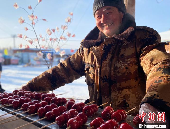 图为冷极村林业工人转型做旅游，展示和游客一起制作的糖葫芦。　张玮 摄