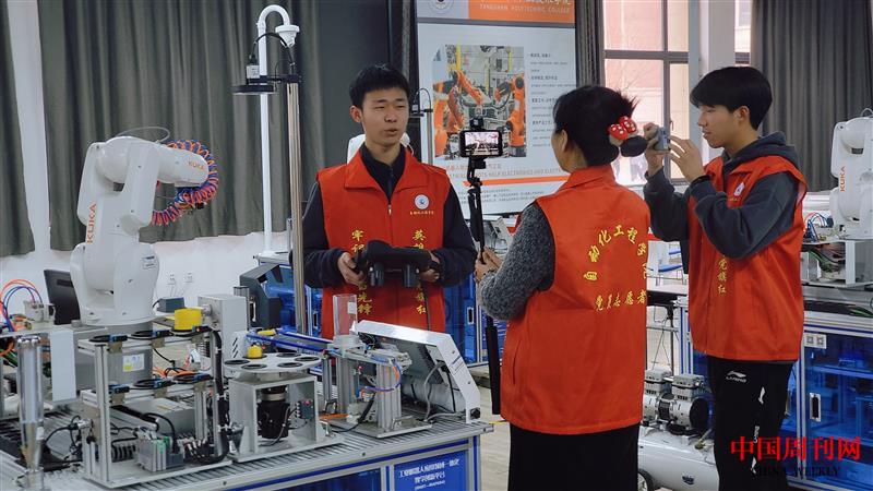 草场8：唐山工业职业技术学院自动化工程学院的师生为队员们讲解电机模型装配机器人整个系统组成及功能展示.jpg